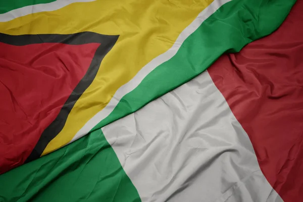 Waving colorful flag of italy and national flag of guyana. — Stock Photo, Image