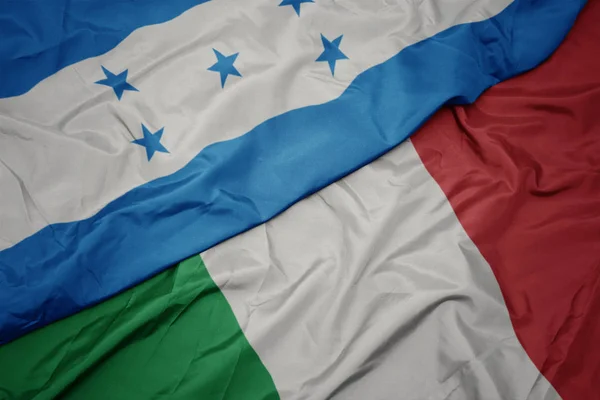 waving colorful flag of italy and national flag of honduras.