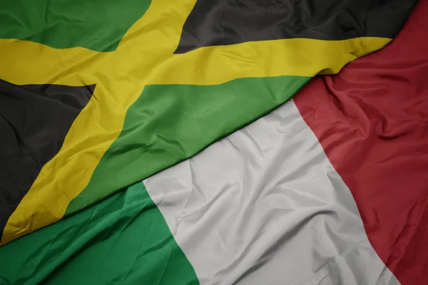 Schwenken bunte Flagge von Italien und Nationalflagge von Jamaica. — Stockfoto