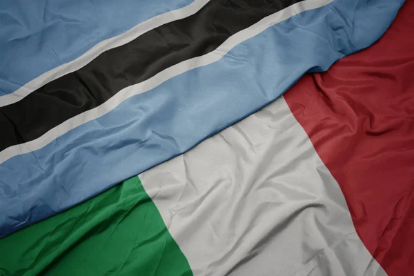 Agitant drapeau coloré de l'Italie et drapeau national du Botswana — Photo