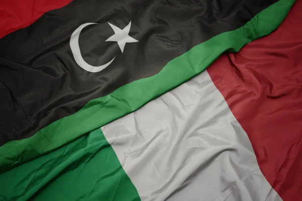 Waving colorful flag of italy and national flag of libya. — Stock Photo, Image