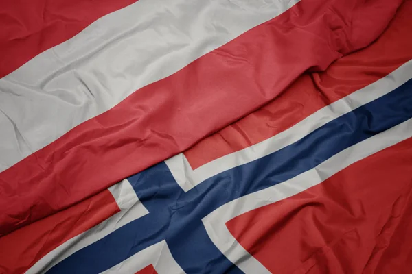 Schwenken bunte Flagge Norwegens und Nationalflagge Österreichs. — Stockfoto