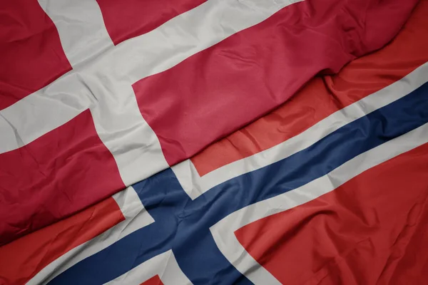 Schwenken bunte Flagge von Norwegen und Nationalflagge von Dänemark. — Stockfoto