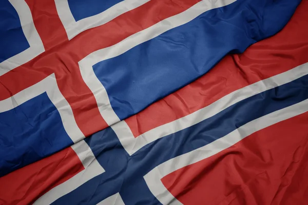Schwenken bunte Flagge von Norwegen und Nationalflagge von Island. — Stockfoto