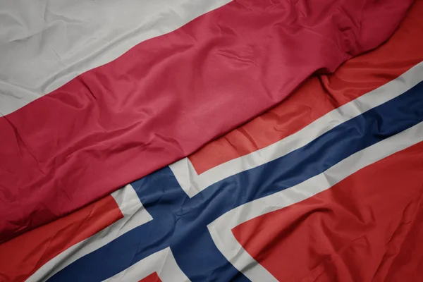 Schwenken bunte Flagge Norwegens und Nationalflagge Polens. — Stockfoto