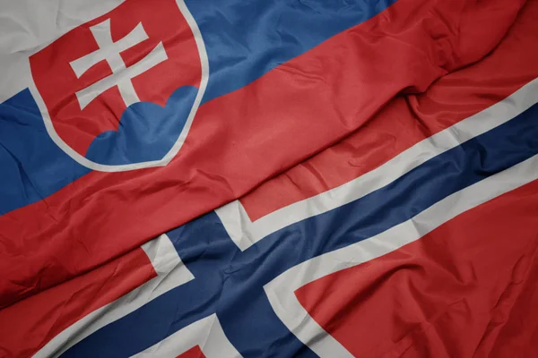 Acenando bandeira colorida de norway e bandeira nacional da eslováquia . — Fotografia de Stock