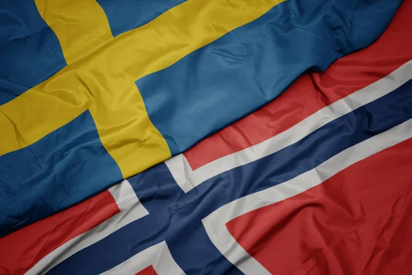 Sventolando bandiera colorata di Norvegia e bandiera nazionale di Svezia . — Foto Stock