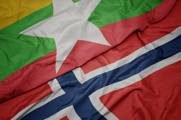 Mávající barvitá vlajka Norska a národní vlajka Myanmaru. — Stock fotografie