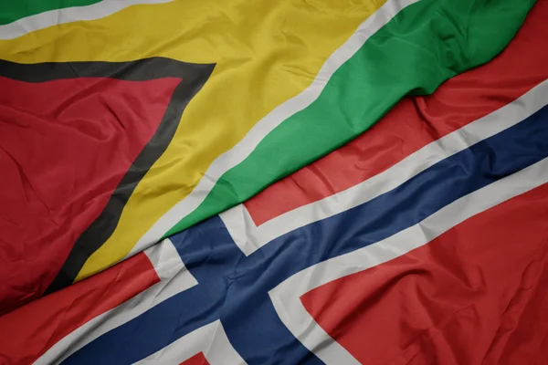Sventolando bandiera colorata della Norvegia e bandiera nazionale della Guyana . — Foto Stock