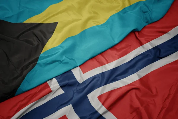 Sventolando bandiera colorata di Norway e bandiera nazionale delle Bahamas . — Foto Stock