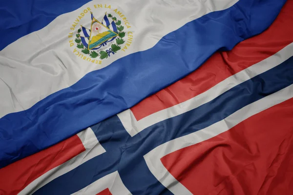 Размахивая красочным флагом Норвегии и национальным флагом Сальвадора . — стоковое фото