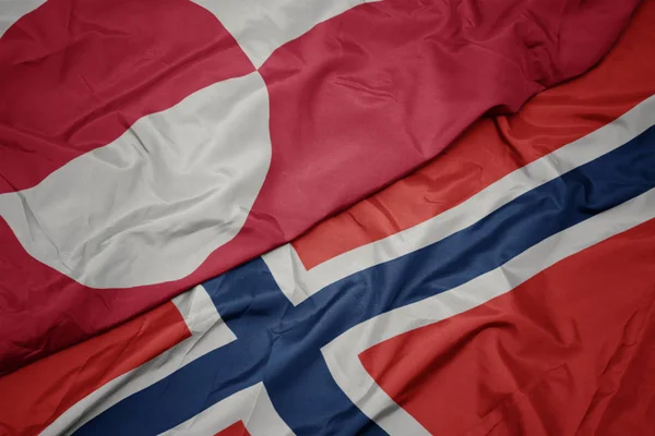 Schwenken bunte Flagge Norwegens und grönländische Nationalflagge. — Stockfoto