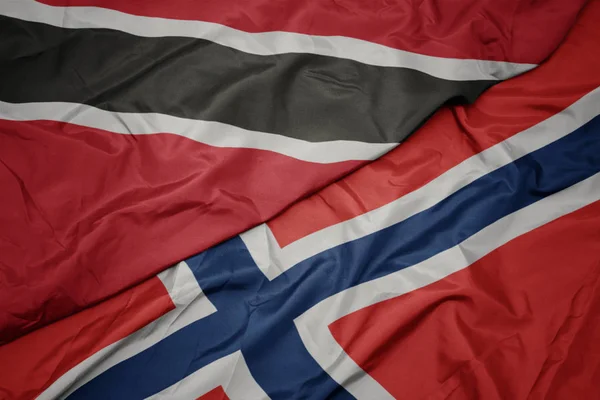 Schwenken bunte Flagge von Norwegen und Nationalflagge von Trinidad und Tobago. — Stockfoto