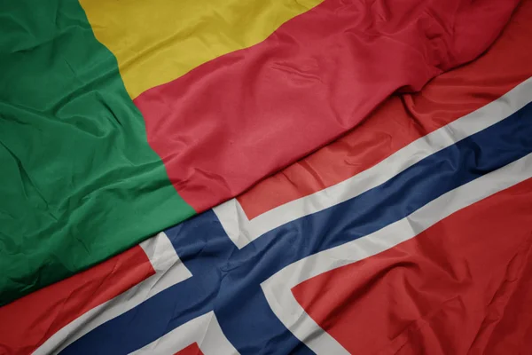 Sventolando bandiera colorata di Norway e bandiera nazionale del Benin . — Foto Stock