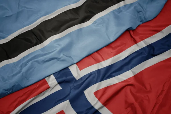 Schwenken bunte Flagge von Norwegen und Nationalflagge von Botswana. — Stockfoto