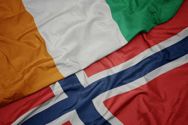 Sventolando bandiera colorata di norway e bandiera nazionale di cote divoire . — Foto Stock
