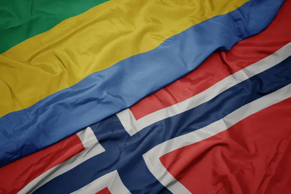 Sventolando bandiera colorata di Norway e bandiera nazionale del Gabon . — Foto Stock
