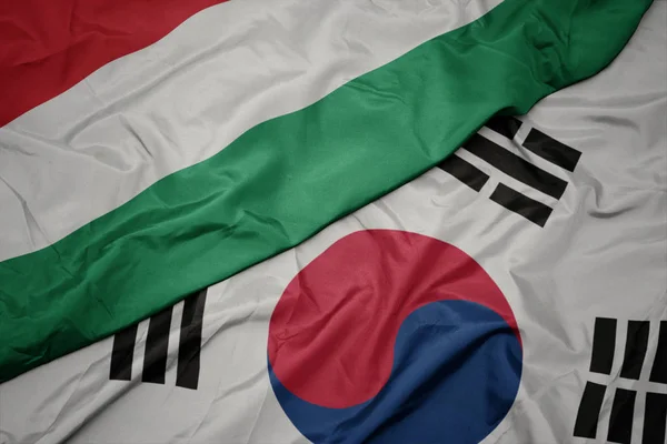 Ondeando colorida bandera de Corea del Sur y bandera nacional de Hungary . — Foto de Stock