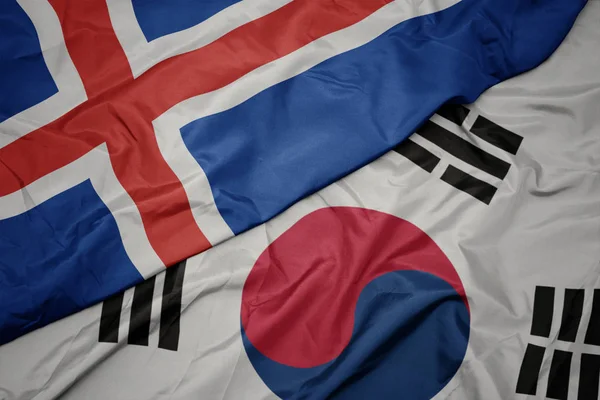 Ondeando colorida bandera de Corea del Sur y bandera nacional de iceland . — Foto de Stock