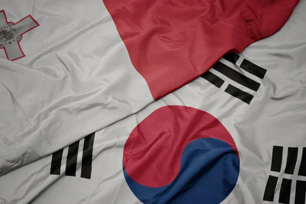 Acenando bandeira colorida da Coréia do Sul e bandeira nacional de malta . — Fotografia de Stock