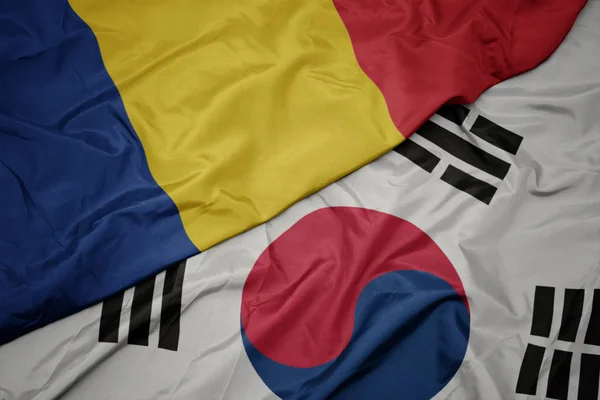 Ondeando colorida bandera de Corea del Sur y bandera nacional de romania . — Foto de Stock