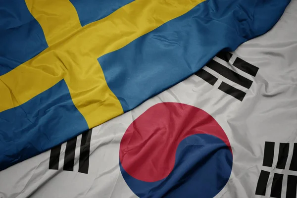 Ondeando colorida bandera de Corea del Sur y bandera nacional de Suecia . — Foto de Stock