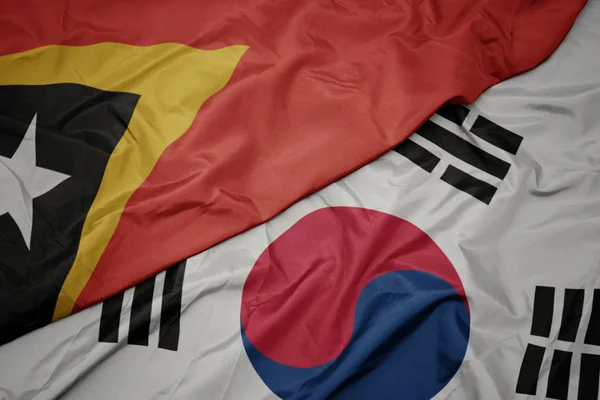 Ondeando colorida bandera de Corea del Sur y bandera nacional de Timor Oriental . — Foto de Stock