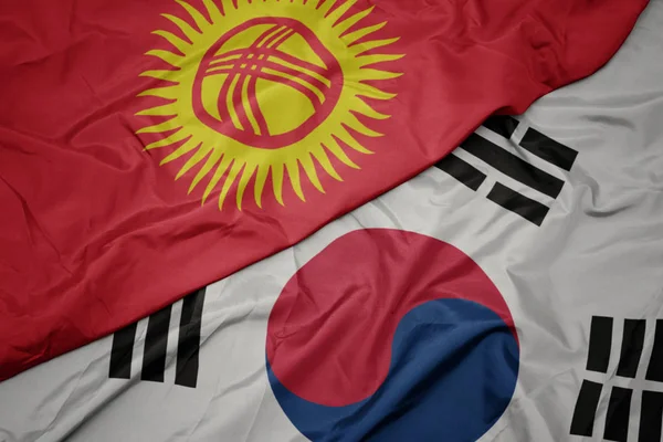 Ondeando colorida bandera de Corea del Sur y bandera nacional de Kirguistán . — Foto de Stock
