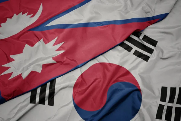 Ondeando colorida bandera de Corea del Sur y bandera nacional de nepal . — Foto de Stock