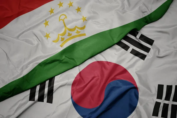 Waving colorful flag of south korea and national flag of tajikistan. — Stock Photo, Image