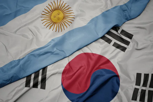 Ondeando colorida bandera de Corea del Sur y bandera nacional de Argentina . — Foto de Stock