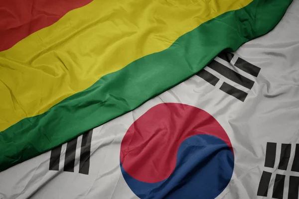 Ondeando colorida bandera de Corea del Sur y bandera nacional de Bolivia . — Foto de Stock