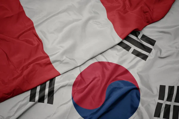 Zwaaiende kleurrijke vlag van Zuid-Korea en de nationale vlag van Peru. — Stockfoto