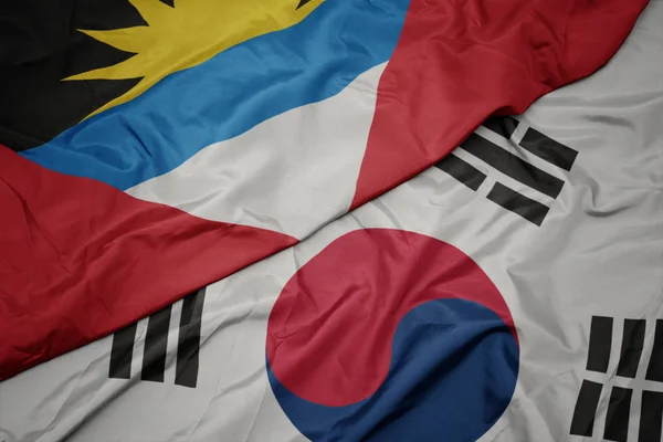 Ondeando colorida bandera de Corea del Sur y bandera nacional de antigua y barbuda . — Foto de Stock