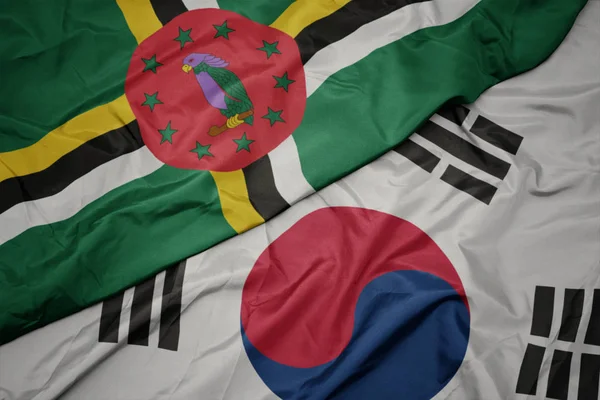 Waving colorful flag of south korea and national flag of dominica. — Stock Photo, Image