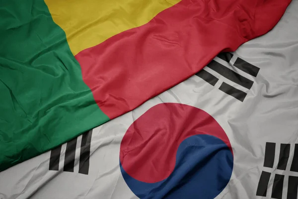 Ondeando colorida bandera de Corea del Sur y bandera nacional de benin . — Foto de Stock