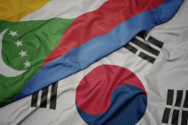 Ondeando colorida bandera de Corea del Sur y bandera nacional de las comoras . — Foto de Stock