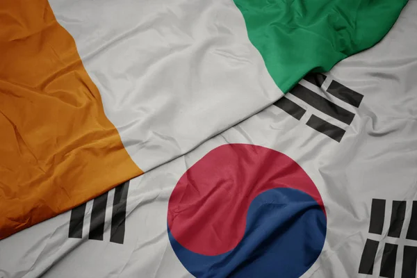 Хвилястий барвистий прапор Південної Кореї та національний прапор Коті-дівуар . — стокове фото