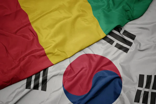 Ondeando colorida bandera de Corea del Sur y bandera nacional de Guinea . — Foto de Stock