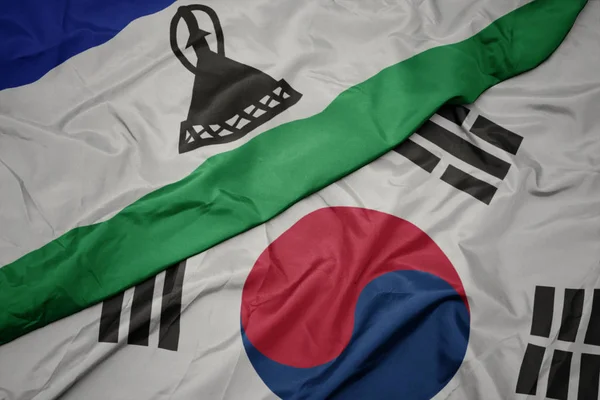 Ondeando colorida bandera de Corea del Sur y bandera nacional de lesotho . — Foto de Stock