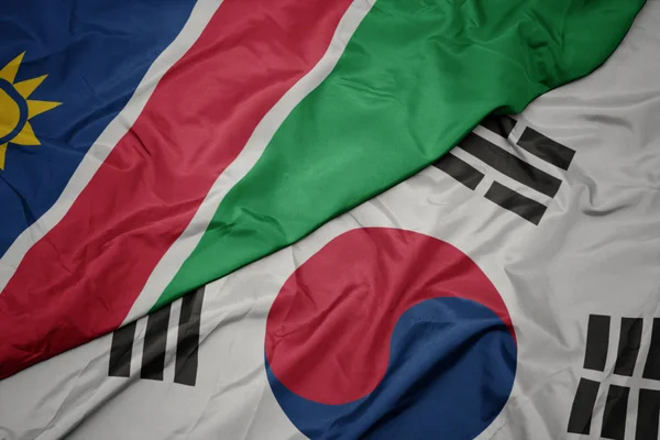 Ondeando colorida bandera de Corea del Sur y bandera nacional de namibia . — Foto de Stock