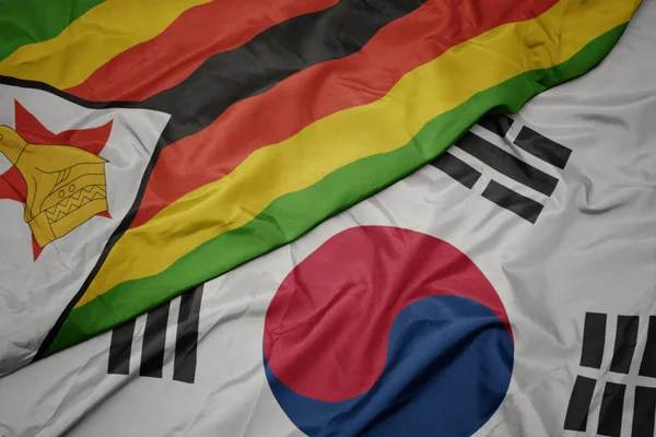 Waving colorful flag of south korea and national flag of zimbabwe. — Stock Photo, Image