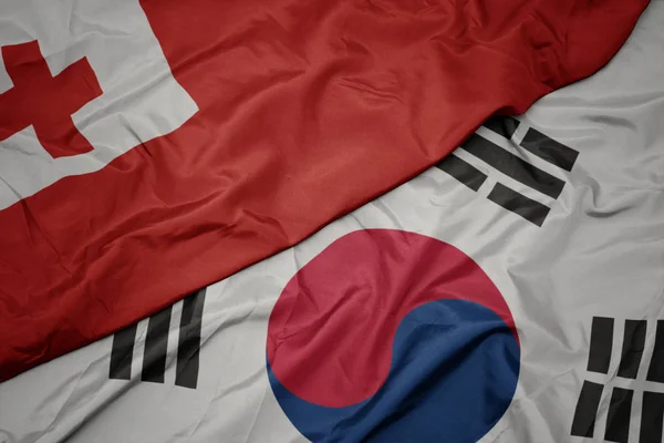 Falujące kolorowe flagi Korei Południowej i flagi narodowej Tonga , . — Zdjęcie stockowe