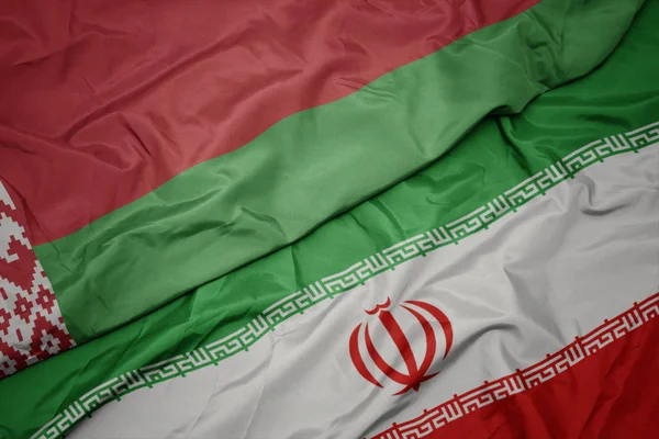 Agitant le drapeau coloré de l'iran et le drapeau national du belarus . — Photo