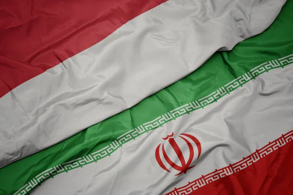 Размахивая красочным флагом Ирана и национальным флагом Индонезии . — стоковое фото