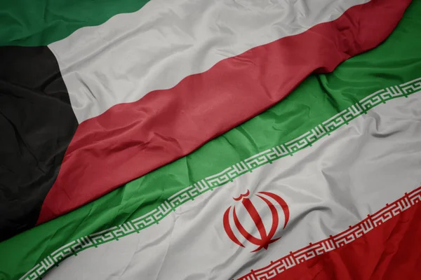 Waving colorful flag of iran and national flag of kuwait. — Stock Photo, Image