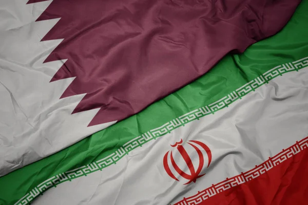 Ondeando colorida bandera de Irán y bandera nacional de qatar . —  Fotos de Stock