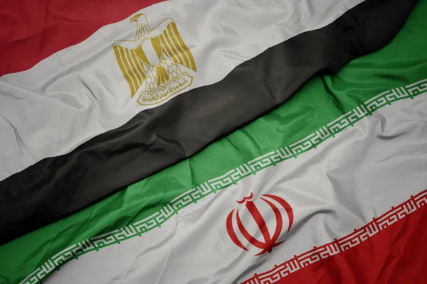 Размахивая красочным флагом Ирана и национальным флагом Египта  . — стоковое фото