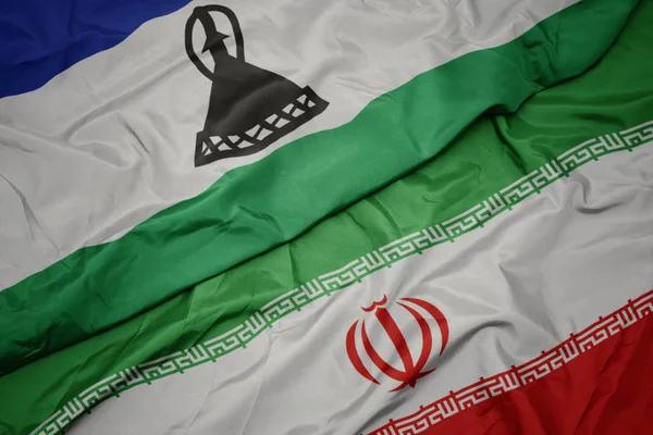 Размахивая красочным флагом Ирана и национальным флагом Лесото . — стоковое фото