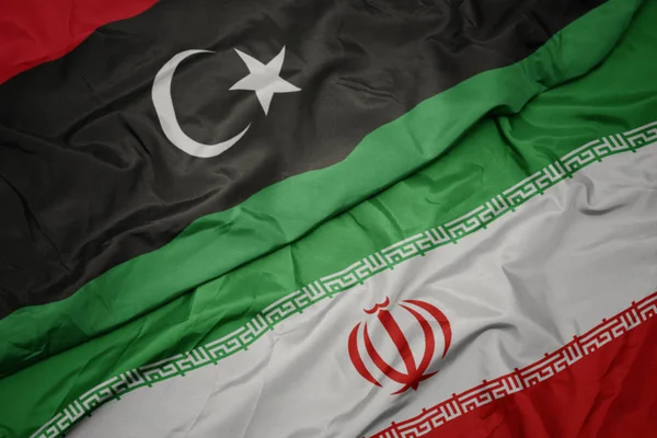 Размахивая красочным флагом Ирана и национальным флагом Ливии . — стоковое фото